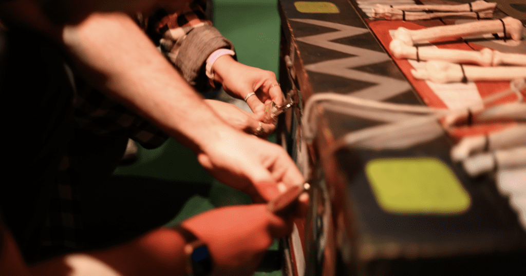 Hands unlocking locks on a cabinet in an escape room