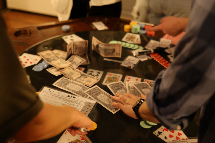 Escape room, saboteur, image with various props laid across it including clue cards and various values of cash.